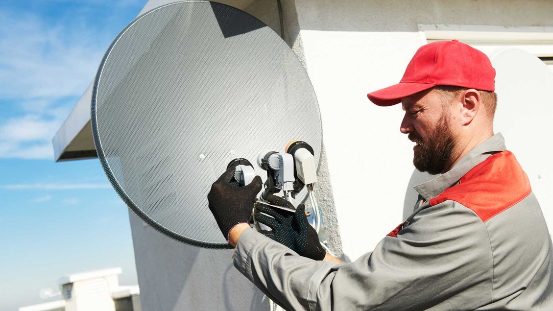 A professional installing a satellite antenna